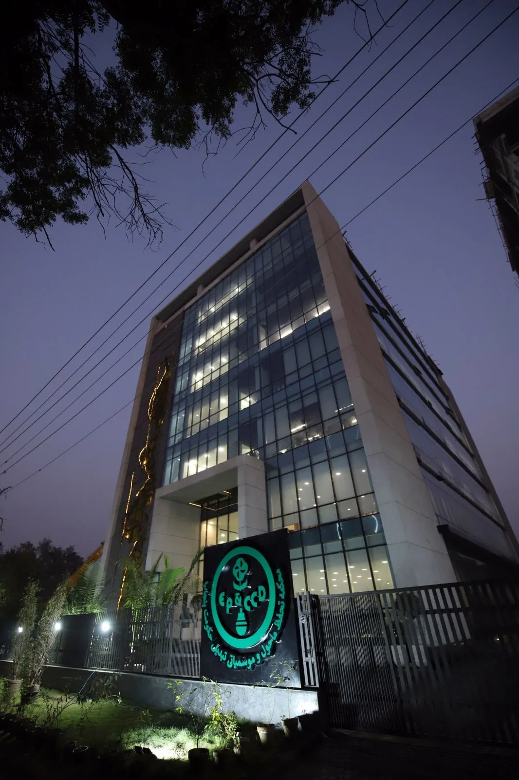 Dusk view with illuminated interiors and gate signage, Green Building, Government of the Punjab, Lahore. LEED Gold-certified government office building. Photo: IDAP.